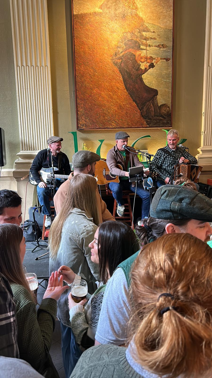 A packed, festive crowd celebrating St. Patrick's Day at The Plough and The Stars