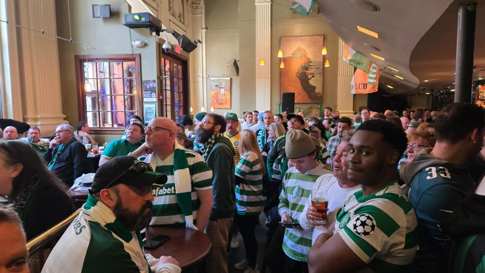 Celtic supporters in hoops packing The Plough and The Stars to watch a match