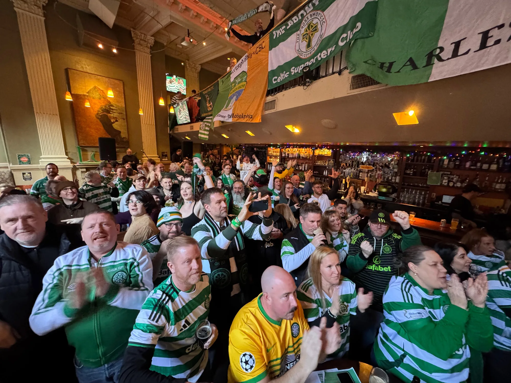 Plough Bhoys supporters celebrating beneath the 2nd Street Celtic Supporters Club banner at The Plough and The Stars