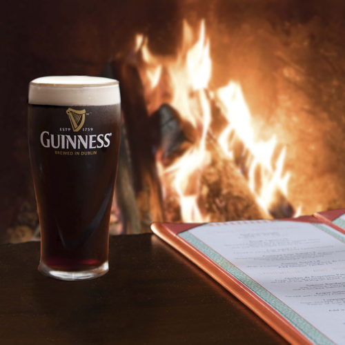 Pint of Guinness by the roaring fire
